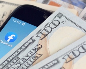 smartphone with Facebook app and hundred dollar bills