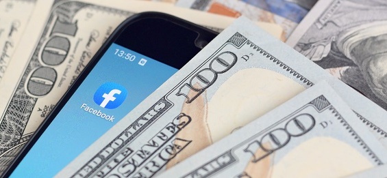 smartphone with Facebook app and hundred dollar bills