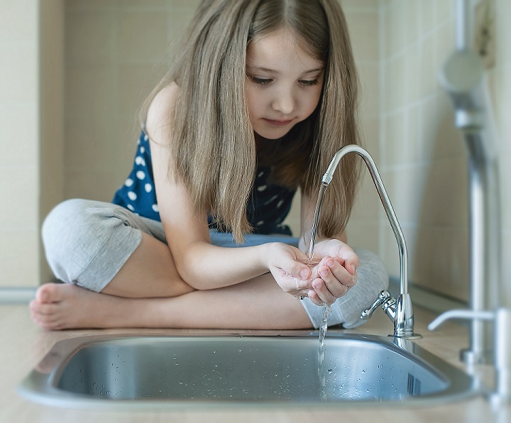 child drinking from filtered tap water