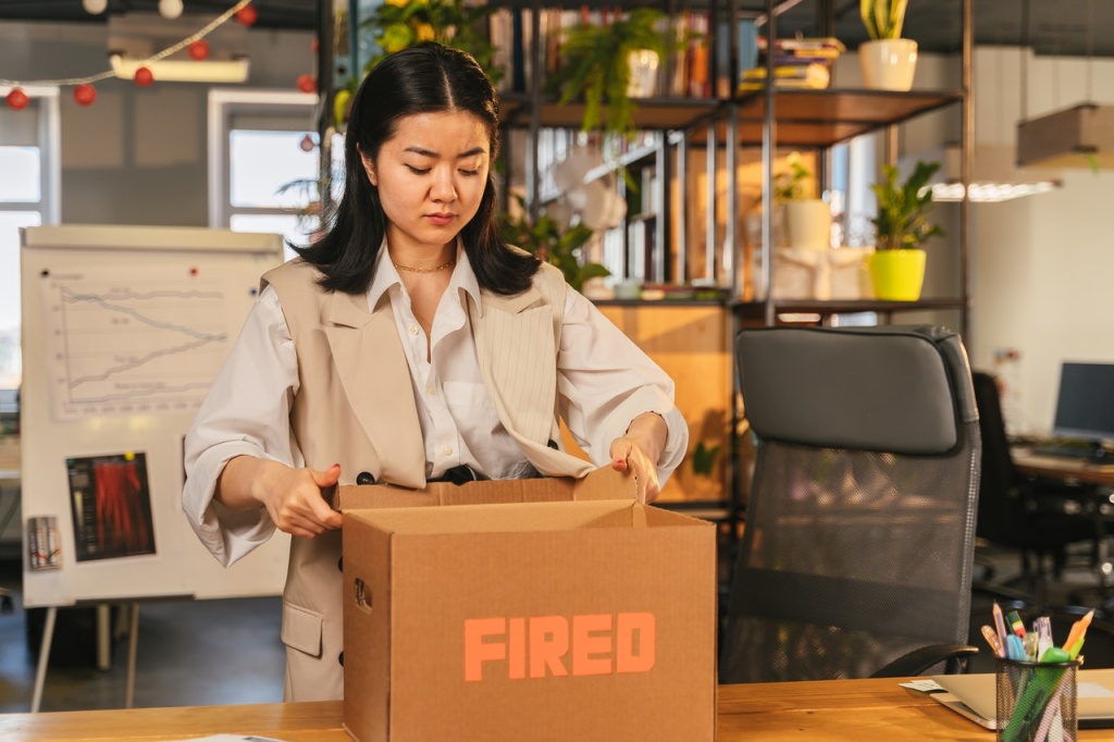 woman packing up her desk after being wrongfully terminated from her job